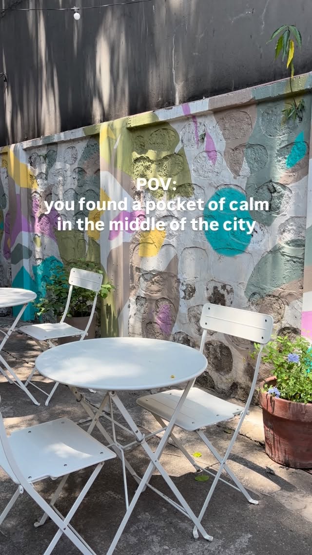OLC outdoor seating — white chairs, colorful mural wall